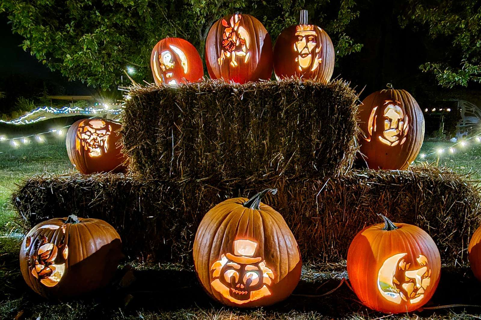 Lit jack-o-lanterns on hay bales